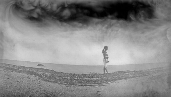 A person standing on top of a sandy beach.
