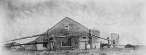 A black and white photo of an old barn.