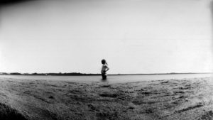 A person standing in the middle of an empty field.