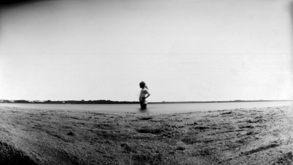 A person standing in the middle of an empty field.