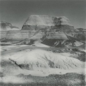 A black and white photo of a mountain with snow on it.