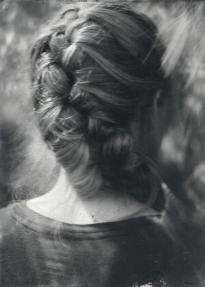A woman with long hair is seen in this black and white photo.