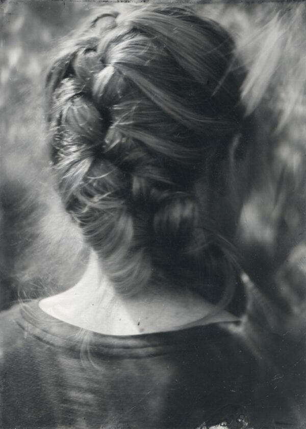 A woman with long hair is seen in this black and white photo.