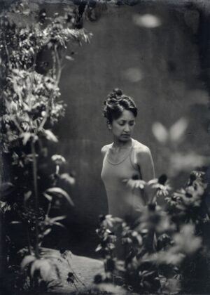 A woman standing in the middle of some bushes