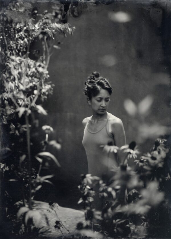 A woman standing in the middle of some bushes