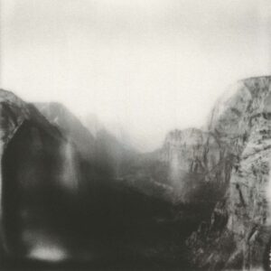 A black and white photo of mountains with fog.