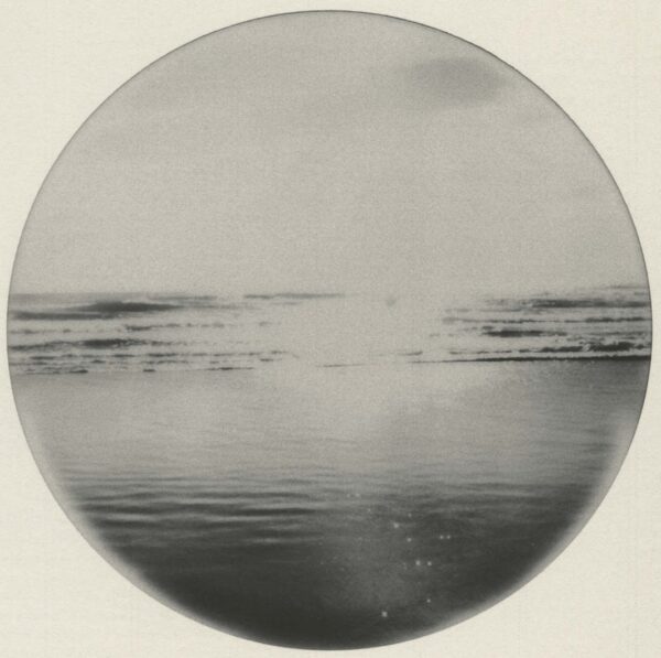 A circular photo of the ocean with waves coming in.