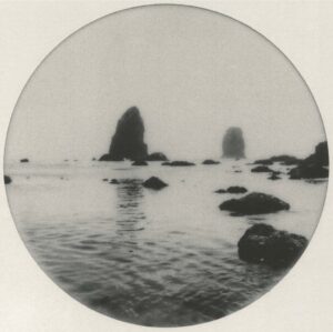 A black and white photo of rocks in the water.