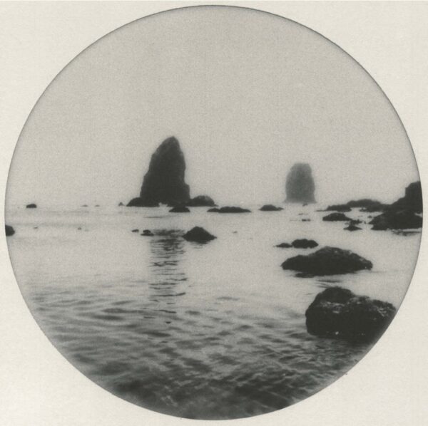 A black and white photo of rocks in the water.