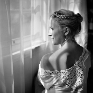 A woman in a white dress looking out of the window