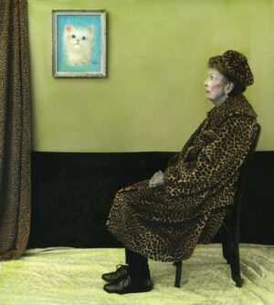 A woman in leopard print sits on a chair.