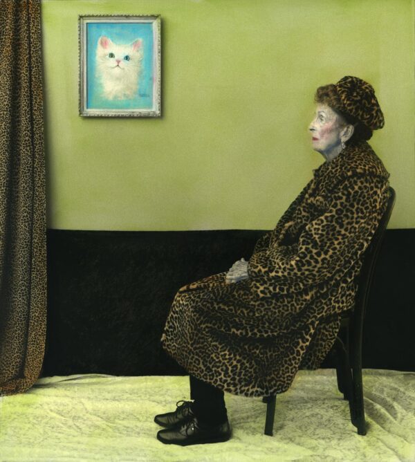 A woman in leopard print sits on a chair.