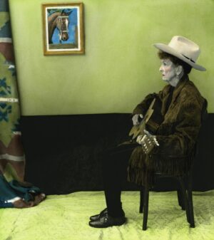 A person sitting in a chair wearing a hat.