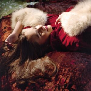 A woman laying on the ground with her hair in the air.
