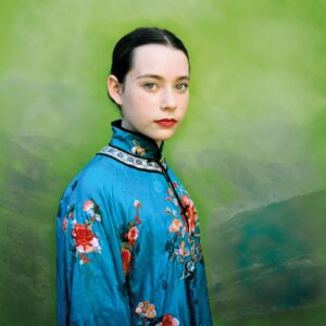 A woman in blue and red floral print jacket.