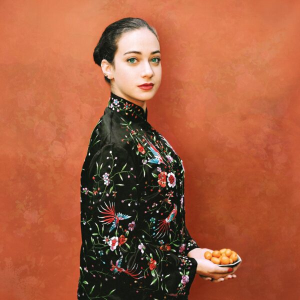 A woman in black and red dress holding food.