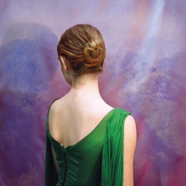 A woman in green dress with her hair up.