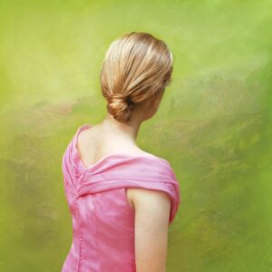 A woman in pink dress standing next to green wall.
