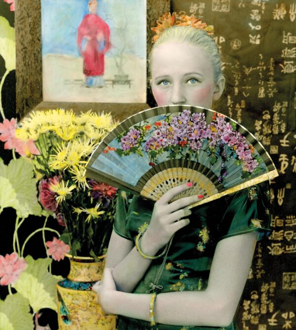 A woman holding a fan in front of her face.