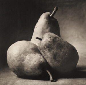 A black and white photo of three pears
