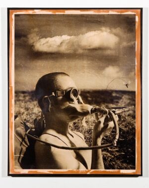 A man with sunglasses and a pipe in his mouth.