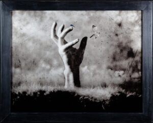 A black and white photo of a person with their arms raised