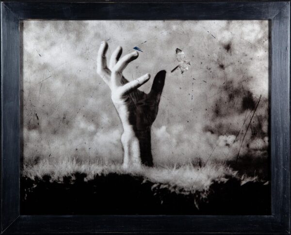 A black and white photo of a person with their arms raised
