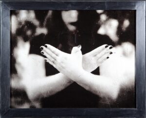 A black and white photo of two hands crossed