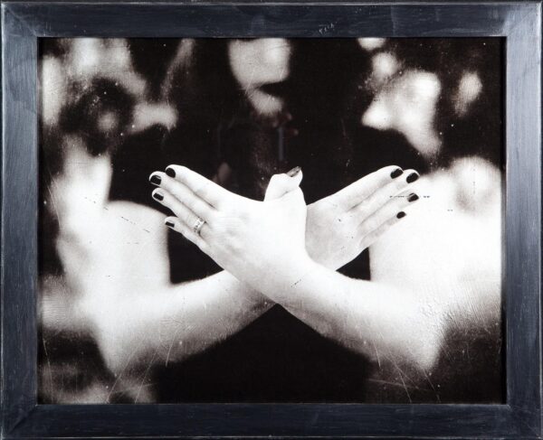 A black and white photo of two hands crossed