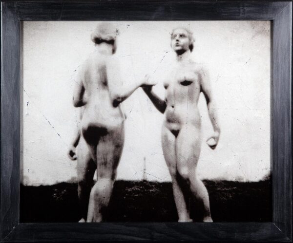 Two women holding hands in a black and white photo.