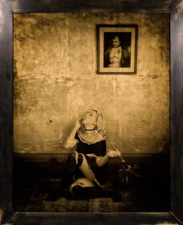 A woman sitting on the ground in front of a wall.