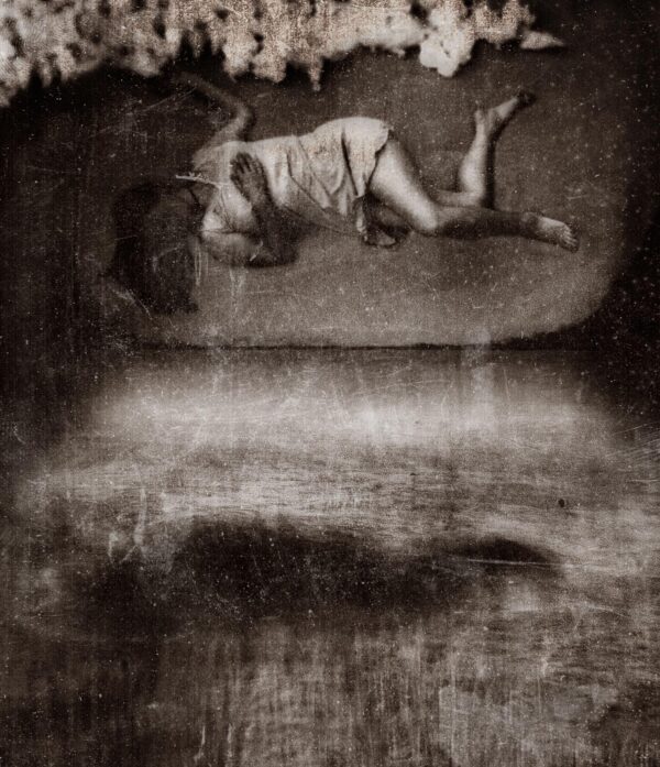 A black and white photo of a person laying on their stomach.