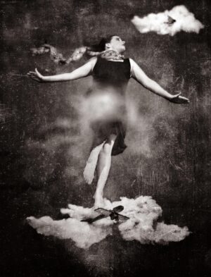 A woman standing on top of clouds with her arms outstretched.