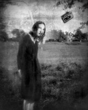 A woman standing in the grass with a kite.