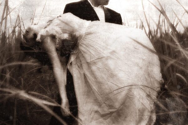 A man and woman in wedding attire standing next to each other.