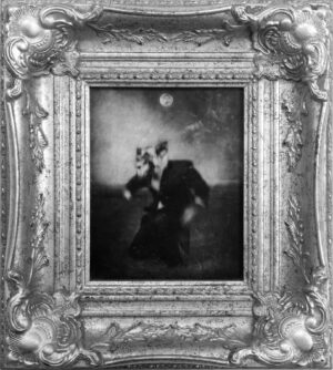 A black and white photo of two people in a picture frame.