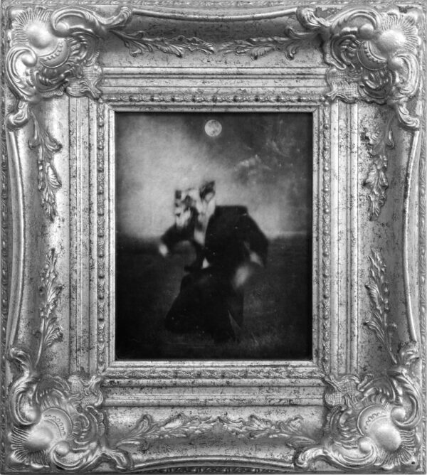 A black and white photo of two people in a picture frame.