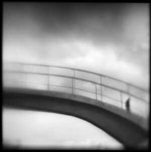 A person standing on top of a bridge.