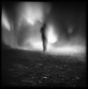 A blurry image of a person walking in the dark.