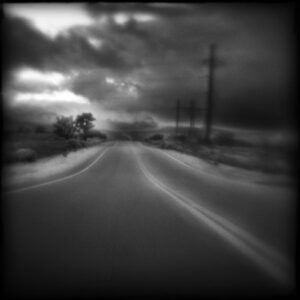 A blurry photo of an empty road with power lines.