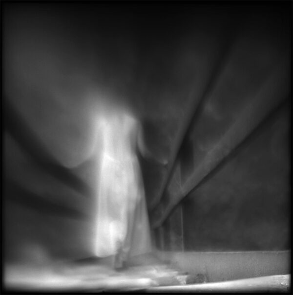 A blurry image of a person standing in the dark.