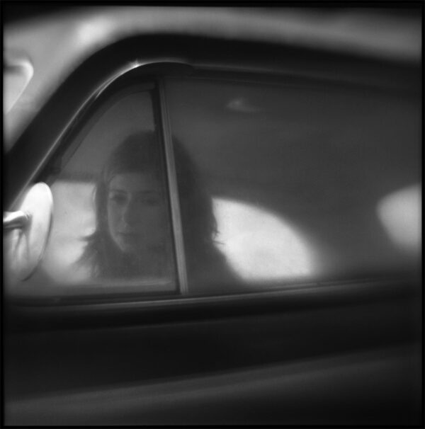 A woman sitting in the passenger seat of a car.