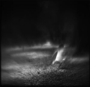 A black and white photo of smoke coming from the ground.