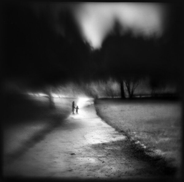 A blurry image of two people walking on the beach
