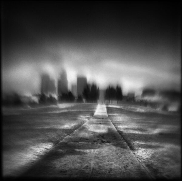 A black and white photo of an empty road.