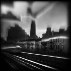 A train is traveling down the tracks in front of a city.