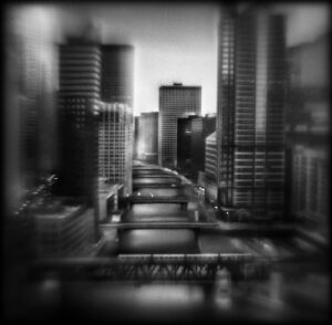 A black and white photo of a city with buildings.