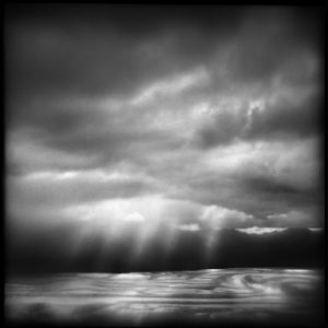 A black and white photo of the sky with clouds