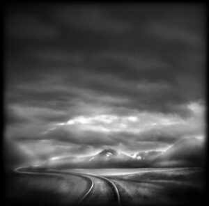 A black and white photo of a road in the middle of nowhere.