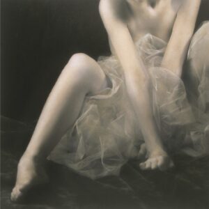 A woman in a white dress sitting on the ground.